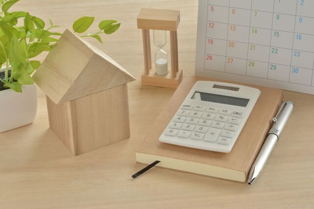 家の形をした木箱と電卓とペンと手帳
